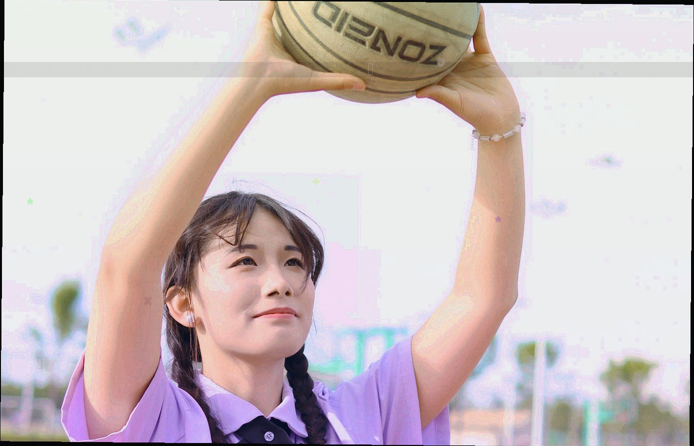 昏暗中羽毛球高速飞行留下的长曝光轨迹，背景是深色球场
